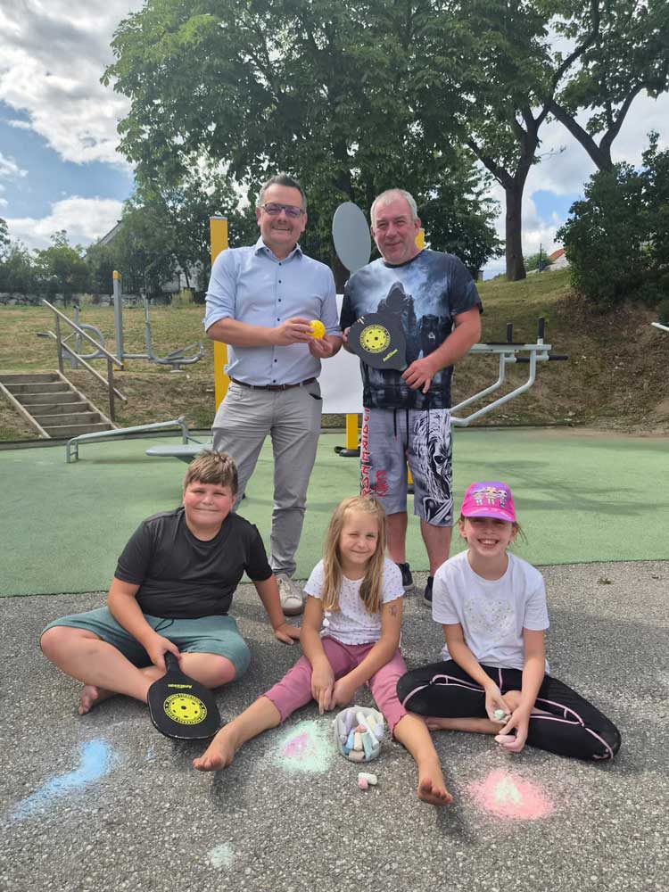 Bürgermeister mit Kindern und Pickleballschlägern am Sportplatz in St. Georgen