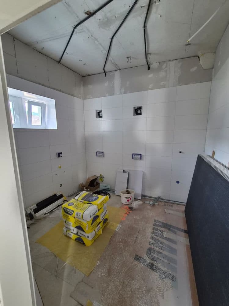 Baustelle mit gestapelten Sackware-Paketen und verlegten Kabeln an der Decke