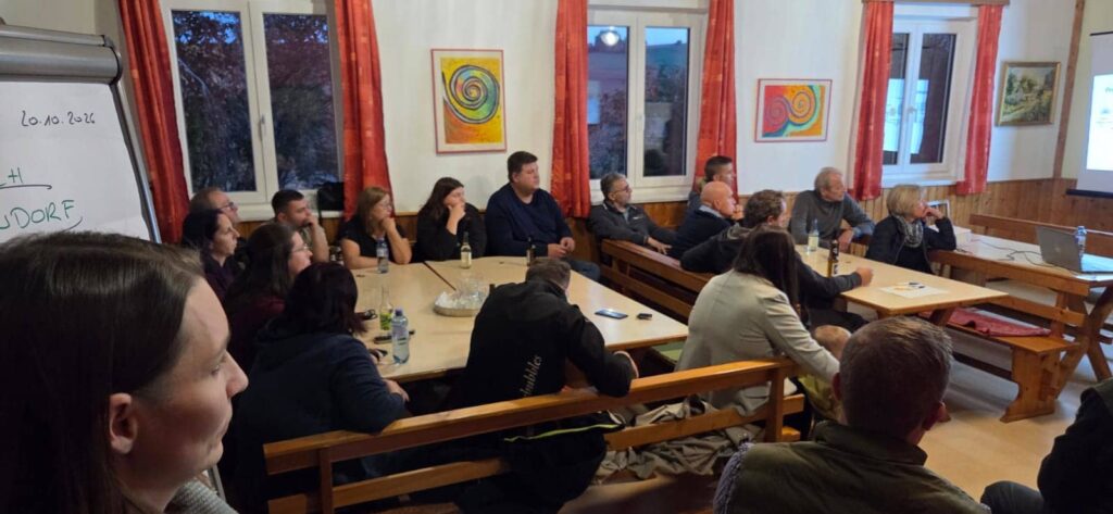 Besprechung in einem Gemeindesaal in Oberösterreich mit mehreren Personen