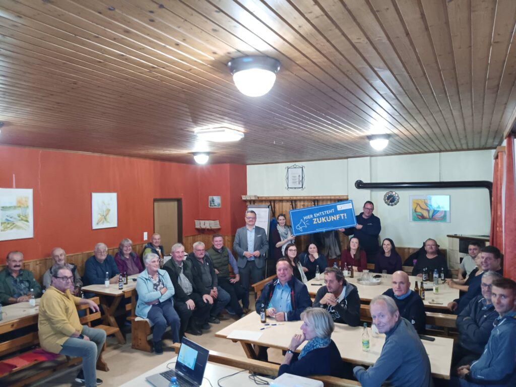 Diskussion über Zukunft in Österreich mit Vertretern, die ein Schild halten.