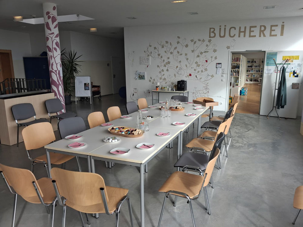 Tafel mit Tellern und Snacks in einem Raum mit der Aufschrift "BÜCHEREI"